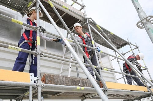 Workers working at height with fall protection.