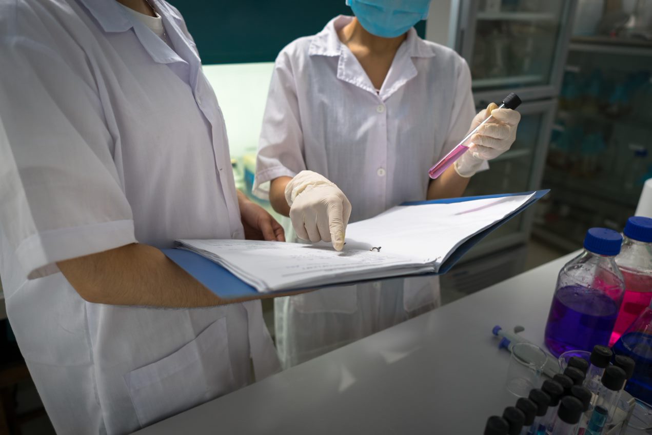 Two people in a lab holding a folder