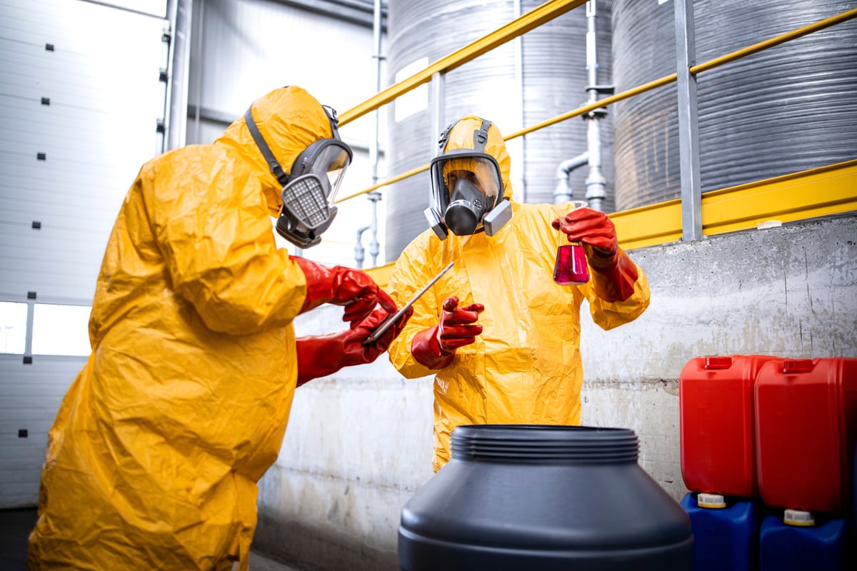 Two workers in protective suits conducting chemical training