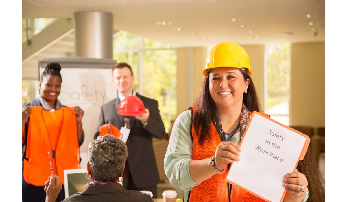 employee holds sign that says safety in the workplace