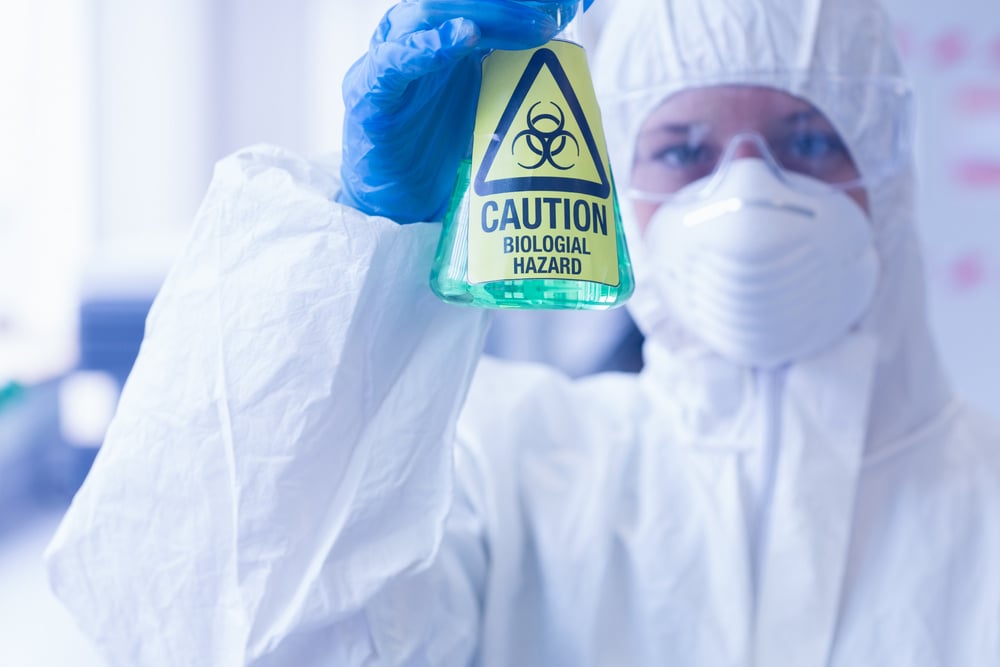 Close-up20of20a20scientist20in20protective20suit20with20hazardous20blue20chemical20in20flask20at20the20laboratory-4
