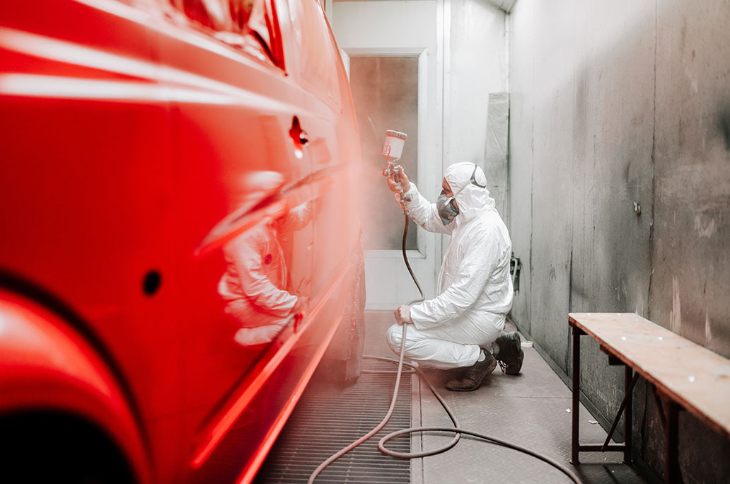 Person spraying car with paint