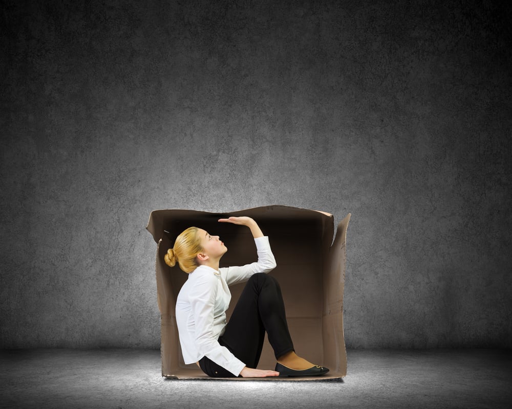 Young20businesswoman20sitting20in20carton20box20and20feeling20uncomfortable-1